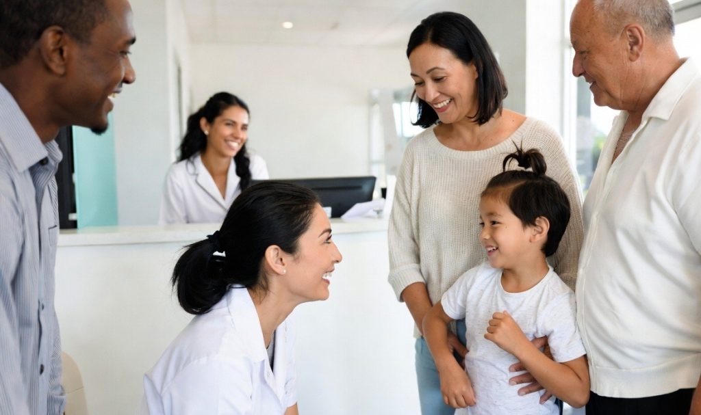 Smiling doctor with a family at All Care Medical and Dental Centre